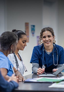 Equipe médica reunida discutindo informações em mesa